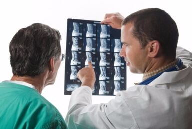 Doctor looks spinal pictures